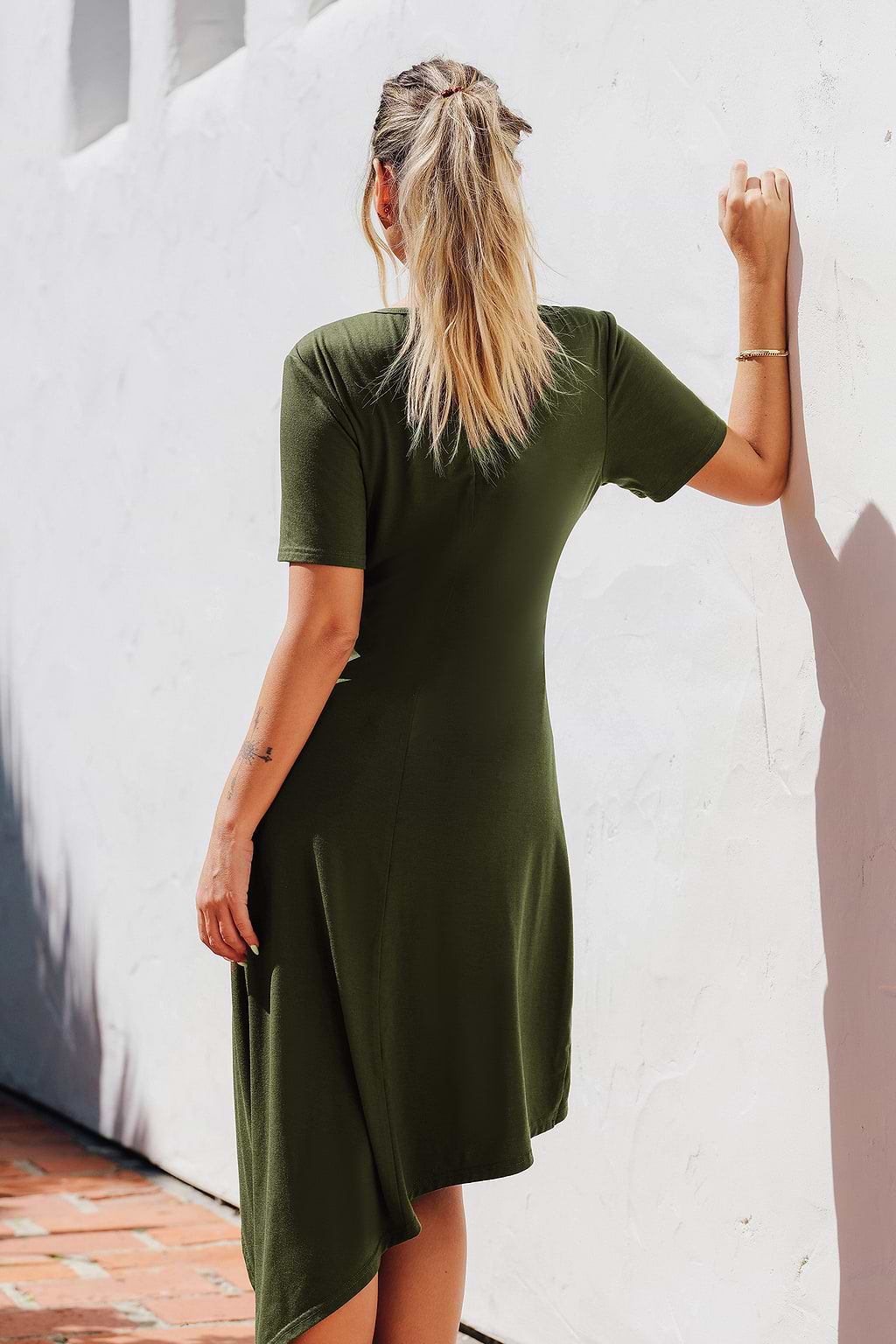 Olijfkleurige jersey jurk met ronde hals  korte mouwen en asymmetrische twist