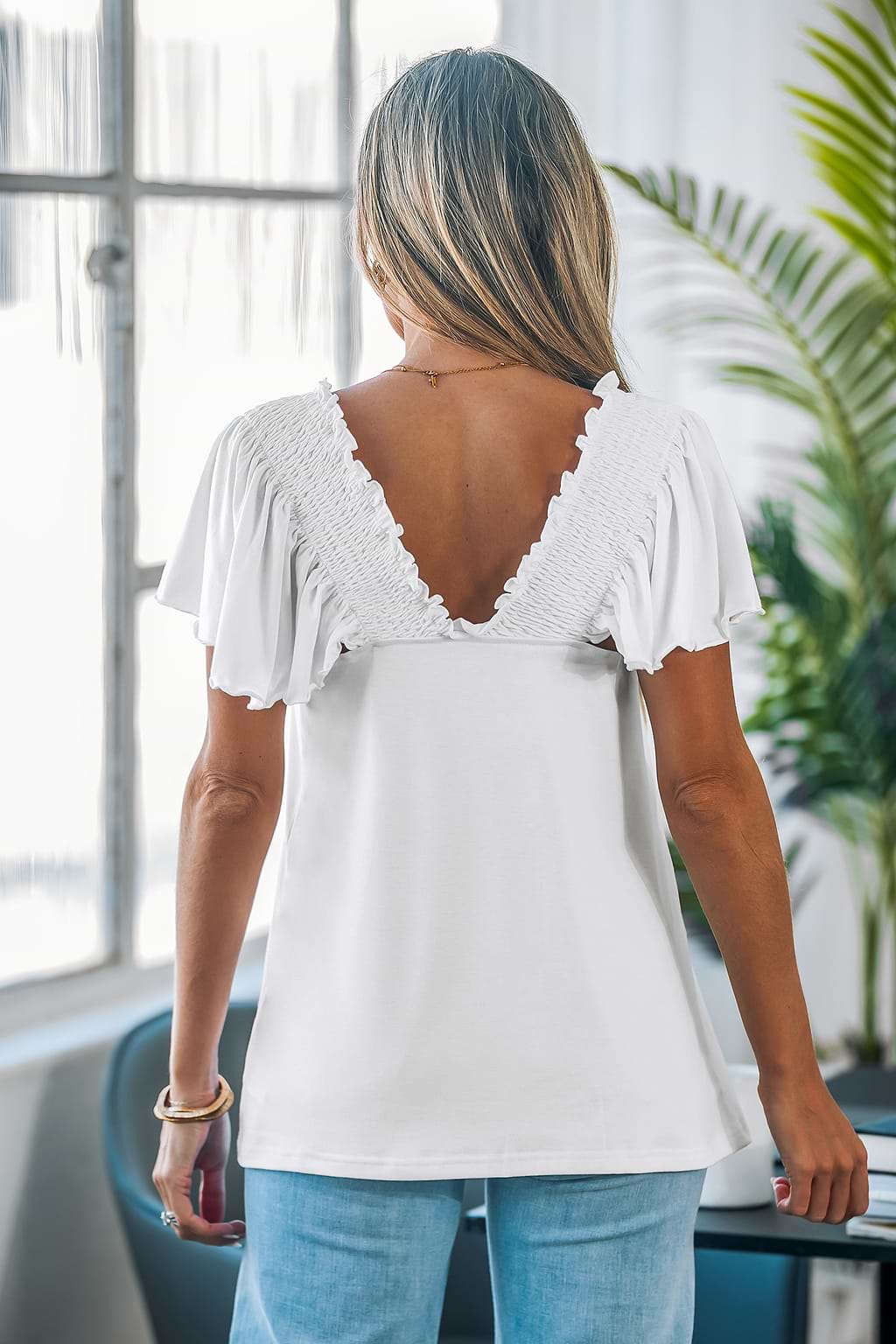 Uitlopende mouwen en smockwerk met V-rug