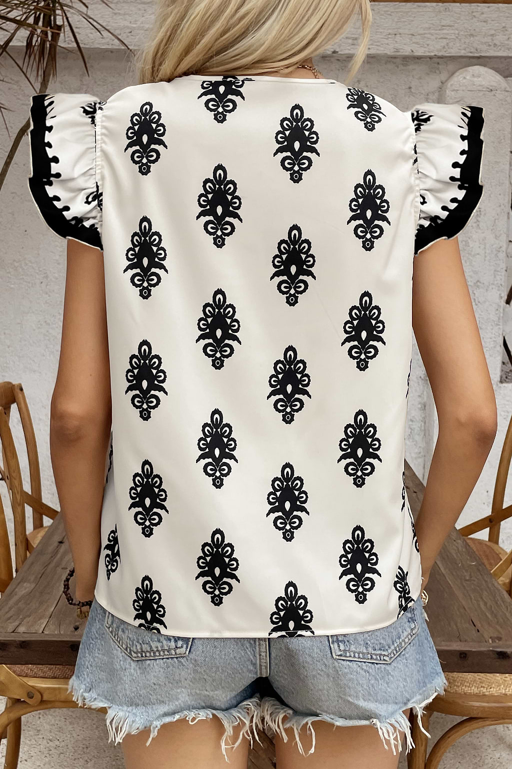 Haut beige et noir avec manches à volants et col en V