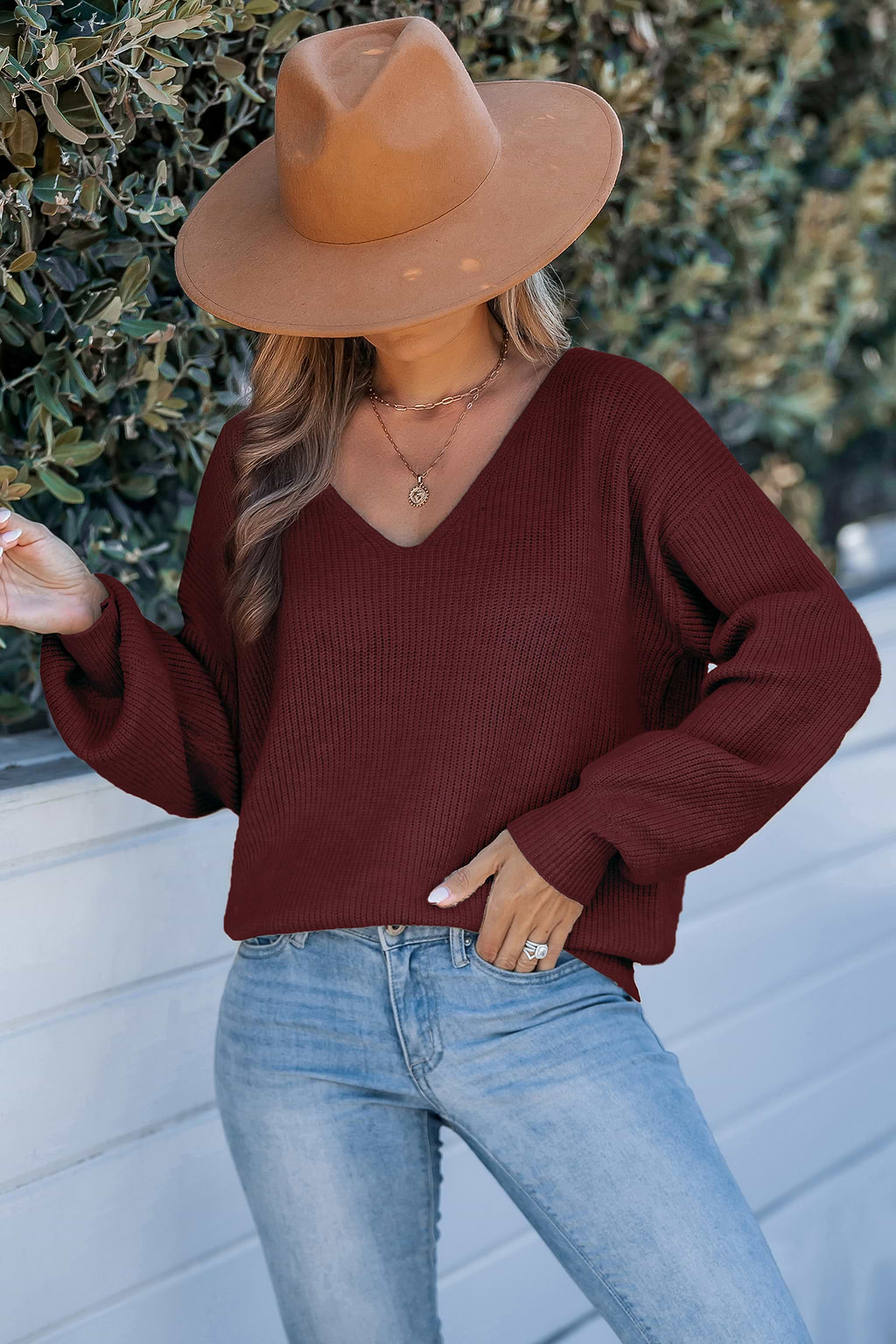 Rode gebreide trui met lange mouwen en strik op de rug