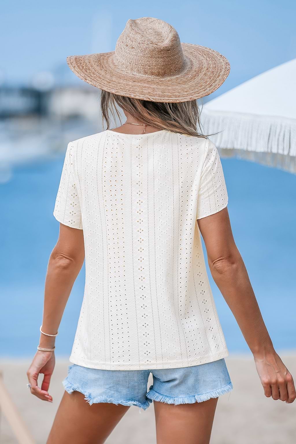 Beige top met V-hals en oogjes met tulpmouwen