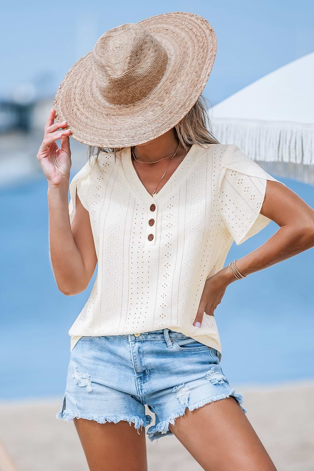 Beige top met V-hals en oogjes met tulpmouwen