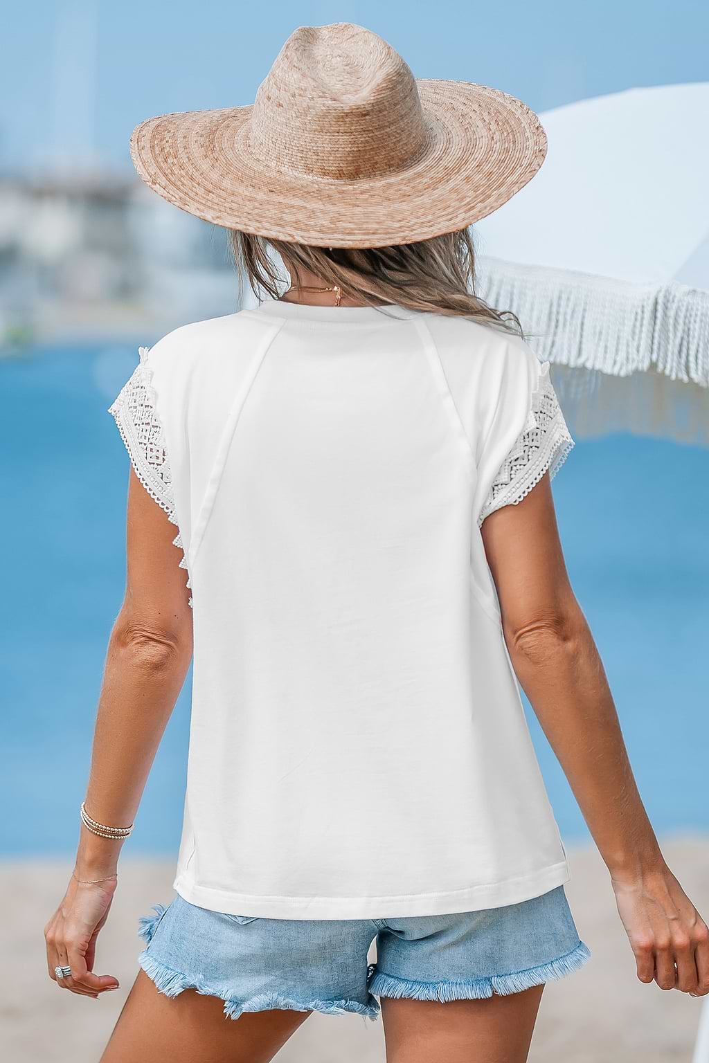 Haut blanc avec col rond en dentelle et manches à volants