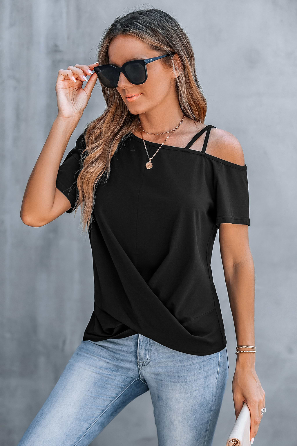 Camiseta negra con corte asimétrico y hombros retorcidos