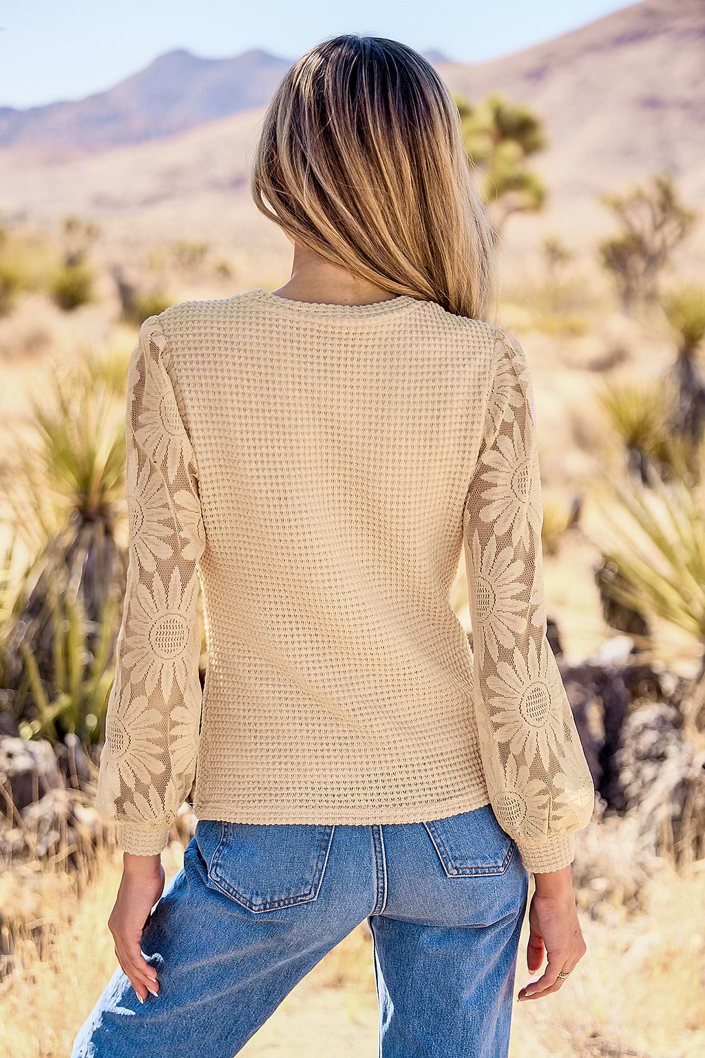 Blusa con cuello alto  mangas largas y transparentes con estampado floral color albaricoque