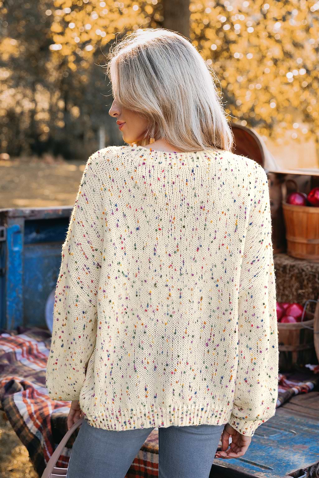 Tęczowy sweter z pomponami i długimi rękawami